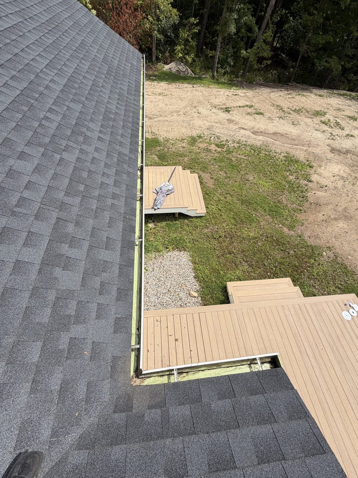 Deck-side gutter corner in Harwinton, Connecticut, after visible leaf debris was removed.