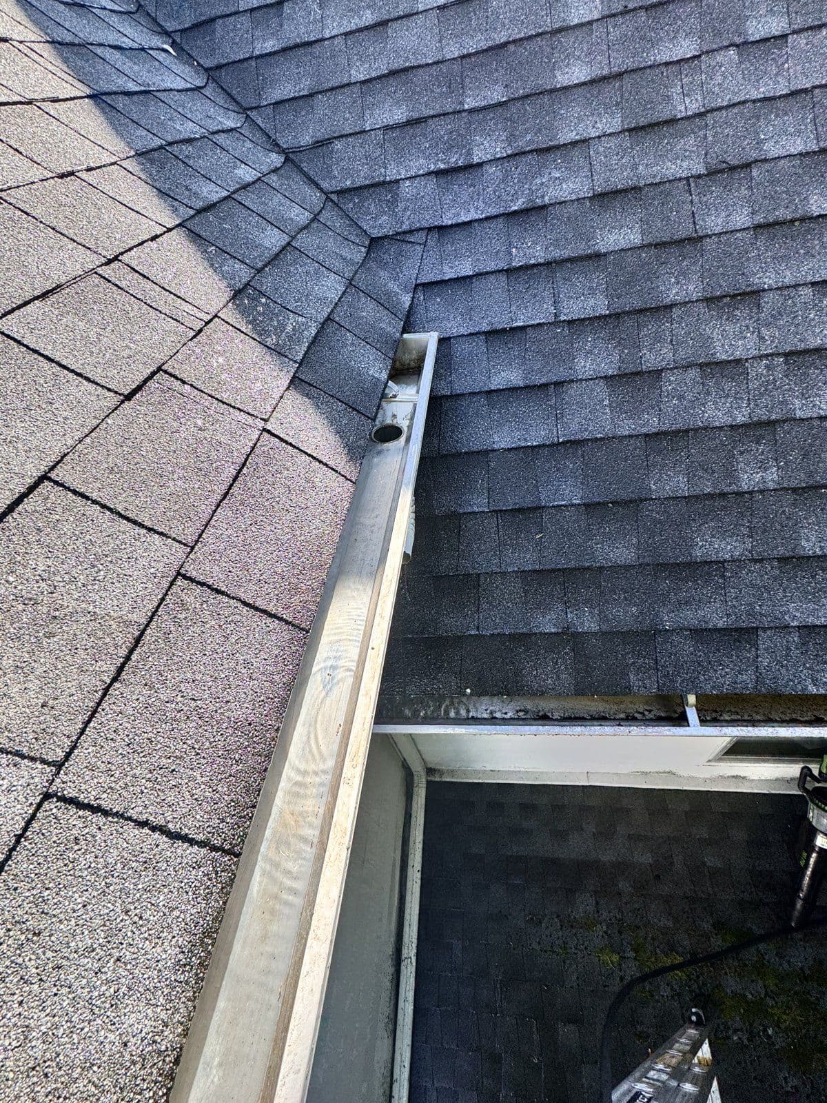 Oxford: The matching gutter corner with debris removed and the outlet visible.