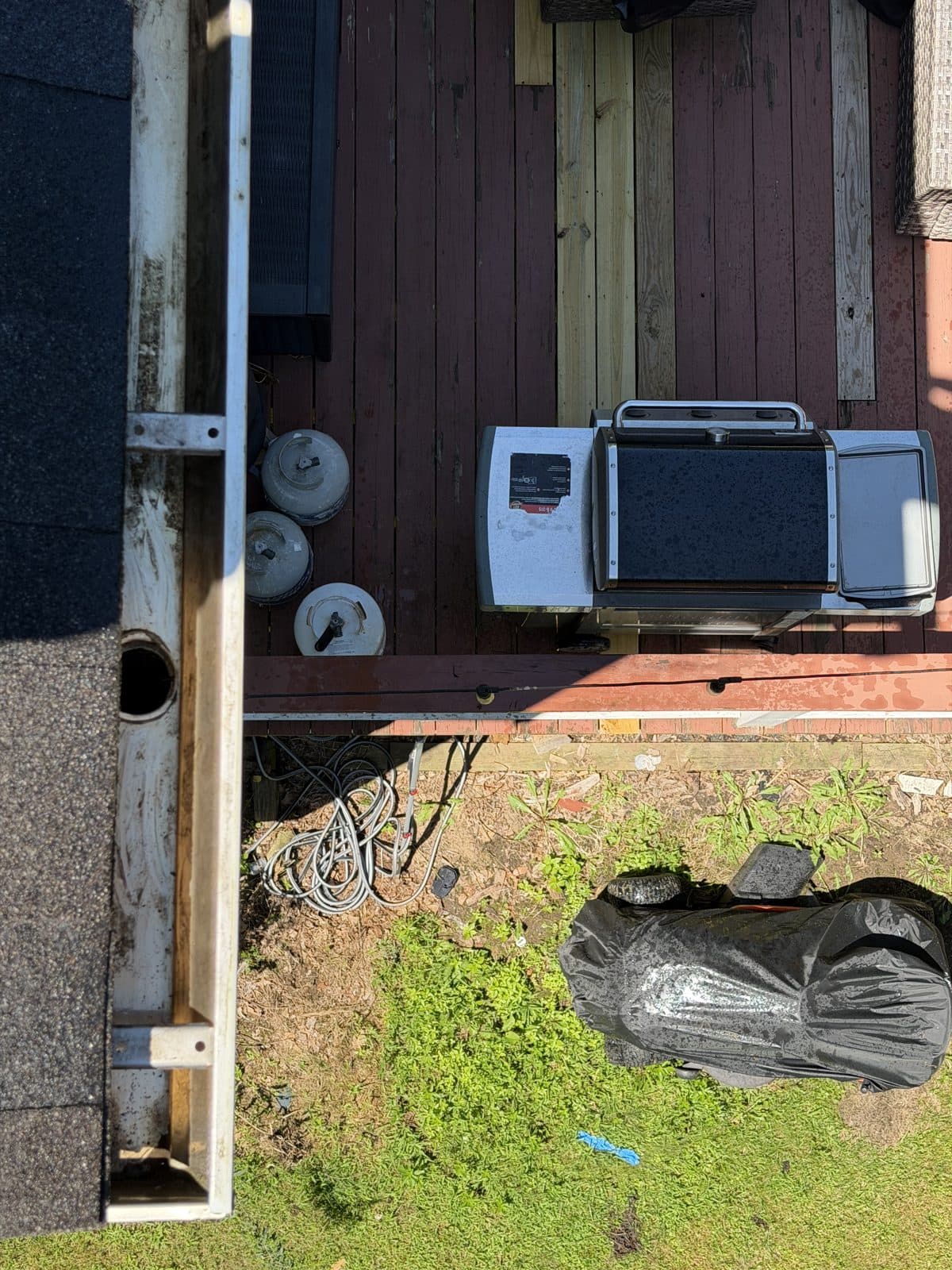 The same Southbury gutter end after accumulated debris removal, with the outlet visible.