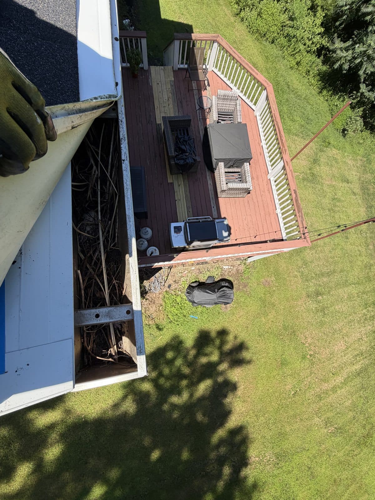 Gutter cover lifted to reveal twigs and debris at a Southbury home before cleaning.